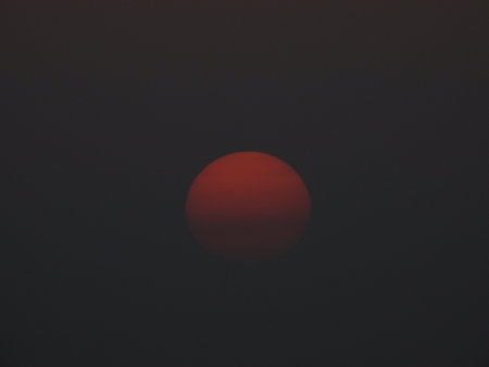 A beautiful orange Sunset coloured  Due to heavy African dust in the atmosphere at that time in early June 2021 near Athens Greeceの写真素材