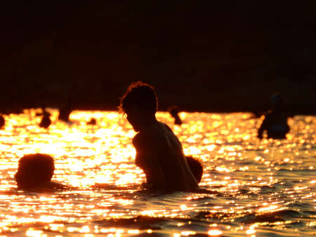 Light Reflection on The Sea during sunset and swimmers in Mediterranean Greece July 6th 2021のeditorial素材