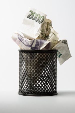 Rumpled, degraded, devaluation of money in black garbageの写真素材