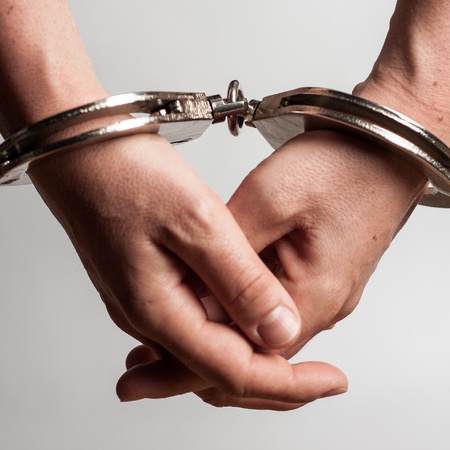 woman arrested with handcuffs on her handsの写真素材
