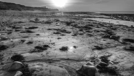 Sunset falling across the beach at East Quantoxhead in Somerset  on an Autumn evening, given the B&W...