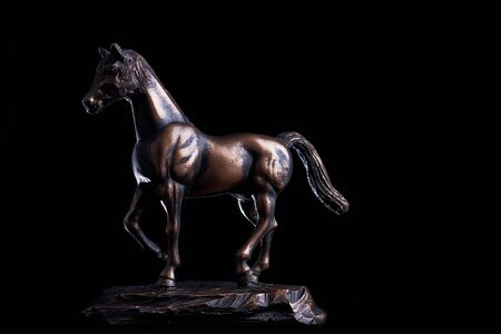 A bronze statuette in studio lighting of a horse doing a Piaffeの写真素材