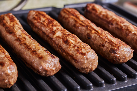 Serbian cevapi, cevapcici, Balkan minced meat kebab. Sausages cooking to grill. Close-upの写真素材