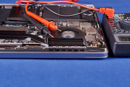 Diagnostics using a tester laptop with a fan in an aluminum case on a blue velvet background....