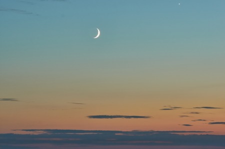 crescent in the sunset sky on the seashore
