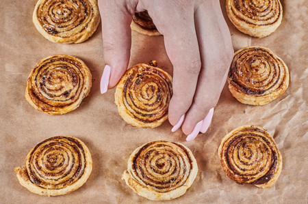 women hand touch puff cookies with chocolate layer on kraft paper backgroundの写真素材