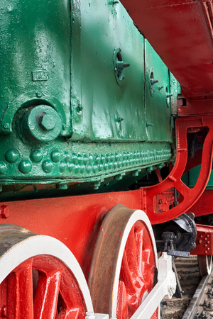 Steel wheels old steam locomotive standing on rails, vintage train, close-up