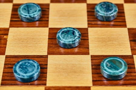 Malachite checkers on a wooden checkerboard. Close-up.の写真素材