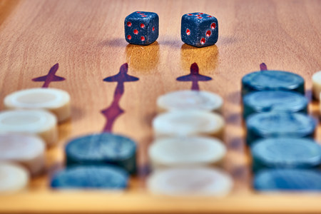 Backgammon game. Game dice made of stone lie on the backgammon board against the background of...