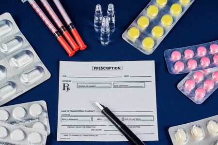 prescription, pen, tablets, syringes and three ampoules on a blue velvet backgroundの写真素材