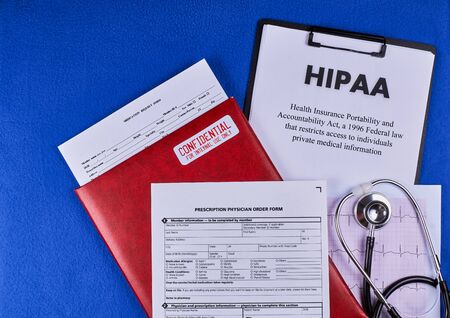 Health Insurance Portability and accountability act HIPAA, red folder with inscription confidential, medication request form, prescription physician order form and stethoscopeの写真素材