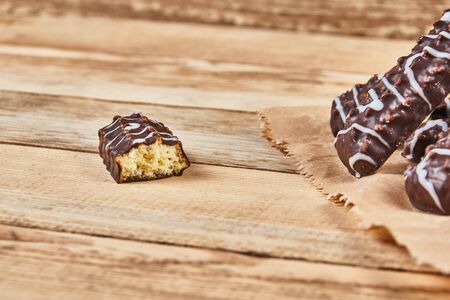 One broken cookie and long sticks shortbread cookies in dark and white chocolate icing in a kraft...
