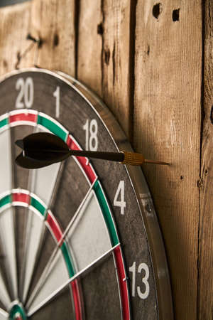 Darts game. Throwing darts at the target. One black dart missed the targetの写真素材