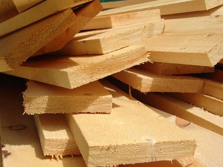 Wooden boards laying on grass on a construction site