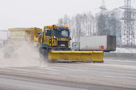 A vehicle cleaning snow on a highway after a snowfallの写真素材