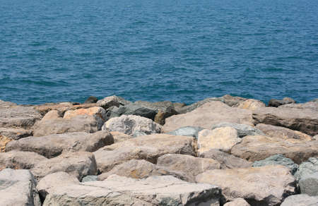 Background of a rocky sea shore with waves behindの写真素材