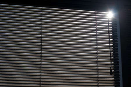 Concept of office life with window blinds and sun shining throughの写真素材
