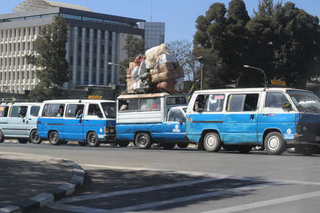 Loaded trucks and blue and white taxis on streets of Addis Ababa, Ethiopia, february 2015のeditorial素材