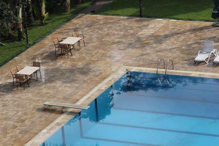 A swimming pool with tables and chairs aroundの写真素材
