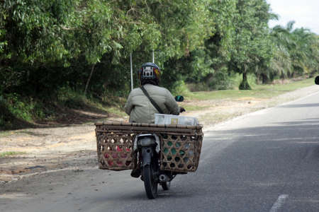A motorcycle driver on a road in Indonesia, november 2013のeditorial素材