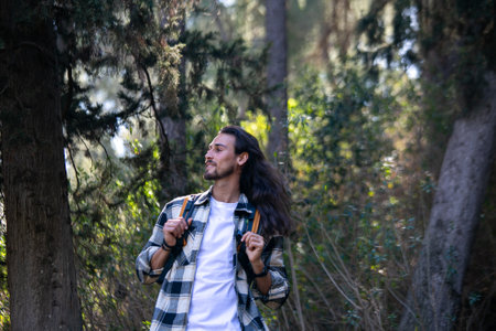 Handsome young man with backpack hiking in the forest. Travel and adventure concept.の写真素材