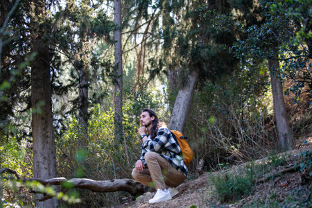 Young couple hiking in the forest. Man and woman sitting on a fallen tree.の写真素材