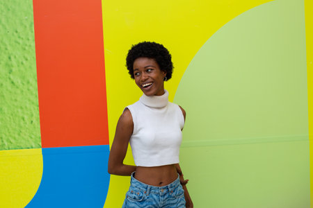 Portrait of a young african american woman smiling against colorful wallの写真素材