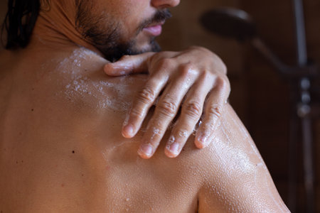 Man taking a shower in the bathroom. Close-up of a man's body.の写真素材