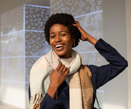 Portrait of a young african american woman wearing coat and scarf in the shopの写真素材