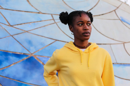 Portrait of african american young woman in yellow hoodie.の写真素材