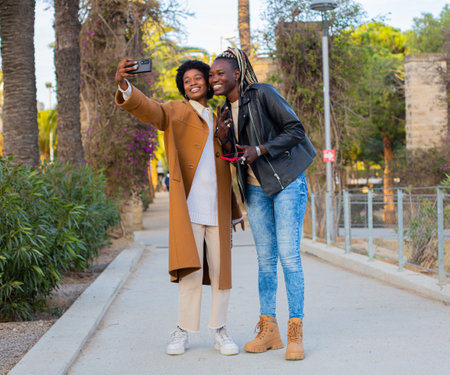 Two african american women taking a selfie on the street.の写真素材