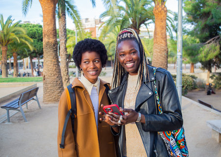 young beautiful afro woman in the city with mobile phoneの写真素材