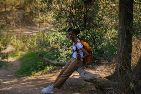Young african american woman with backpack hiking in the forest.の写真素材