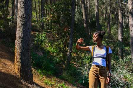 Young african american woman hiking in forest. Travel and adventure concept.の写真素材
