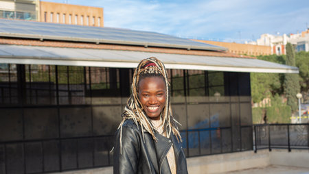 Portrait of young african american woman with dreadlocks smiling outdoors