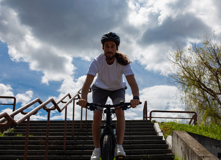 Cyclist Riding a Mountain Bike Down Stairs in a Park