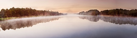 Panorama of sunrise over the misty lakeの写真素材