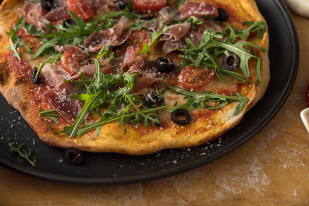 Traditional pizza with prosciutto and arugulaの写真素材