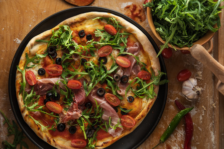 Traditional pizza with prosciutto and arugulaの写真素材
