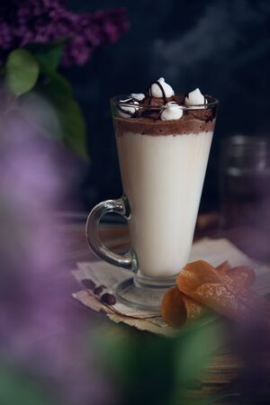 Caffe latte on dark moody background with flowers.の写真素材