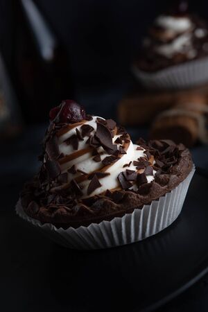 Chocolate cookie with cream and cherries on dark backgroundの写真素材