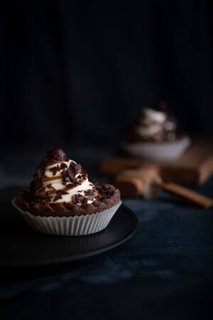 Chocolate cookie with cream and cherries on dark backgroundの写真素材