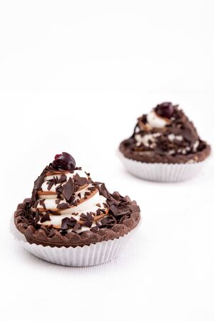 Chocolate cookie with cream and cherry on whiteの写真素材
