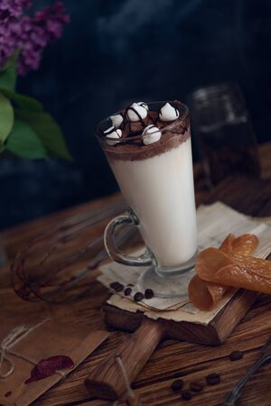 Caffe latte on dark moody background with flowers.の写真素材
