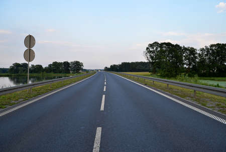 Photo of dark asphalted road and metall barrier 
