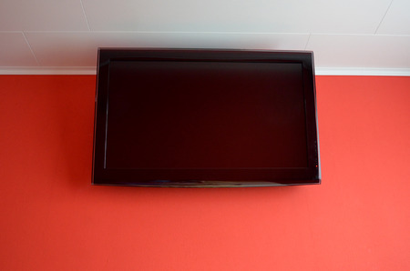 Black ceiling off lcd tv screen on red wall 