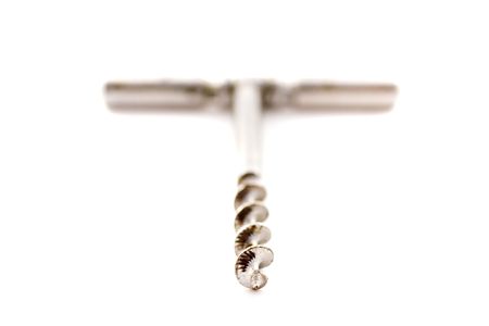 Toned photograph of stainless steel corkscrew on white background shot very high key.