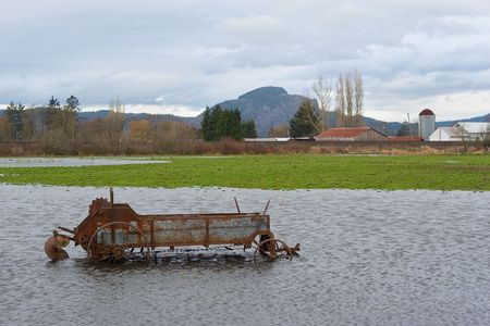 Photo of  piece of antique farming equipment in the flooded pastures of Brownsmead, near Astoria, Oregonの写真素材