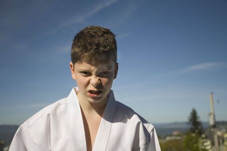 Photo of a boy in his Tae Kwon Do suite isolated against white backgroundの写真素材
