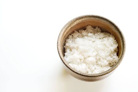 Photo of a ceramic bowl with white rice on white.の写真素材